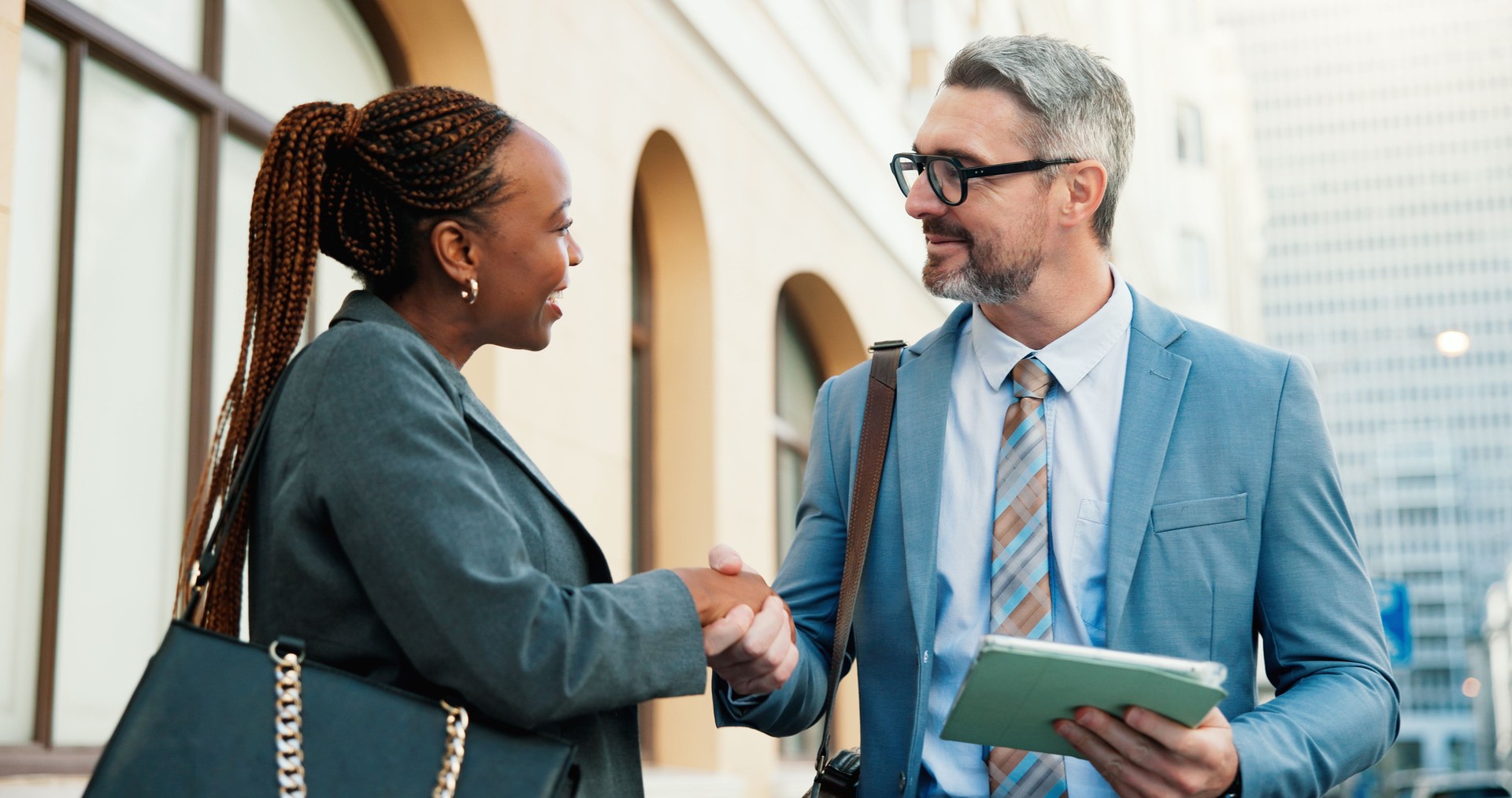 Happy, people or tablet with handshake in city for welcome, client representation and legal support. Tech, woman and defense attorney with shaking hands outdoor for trial hearing and case agreement